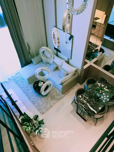 Luxurious modern living room with elegant decor and open dining area, featuring stylish lighting and plush seating.