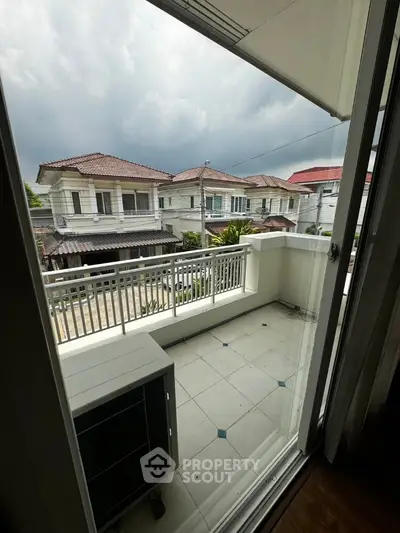 Charming balcony view of suburban houses with cloudy sky