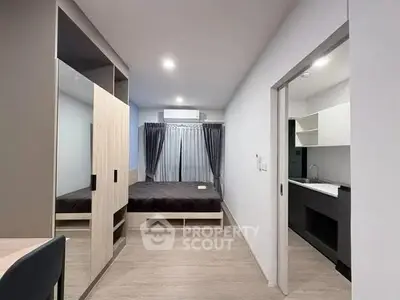 Modern studio apartment with sleek design and open layout, featuring a cozy bedroom and compact kitchen.
