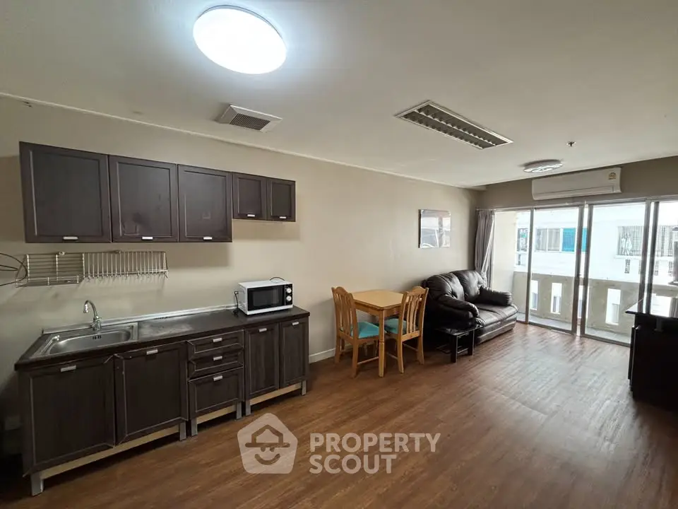 Spacious open-plan living room with modern kitchen and balcony access