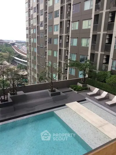 Modern apartment building with pool and city view, ideal for urban living.