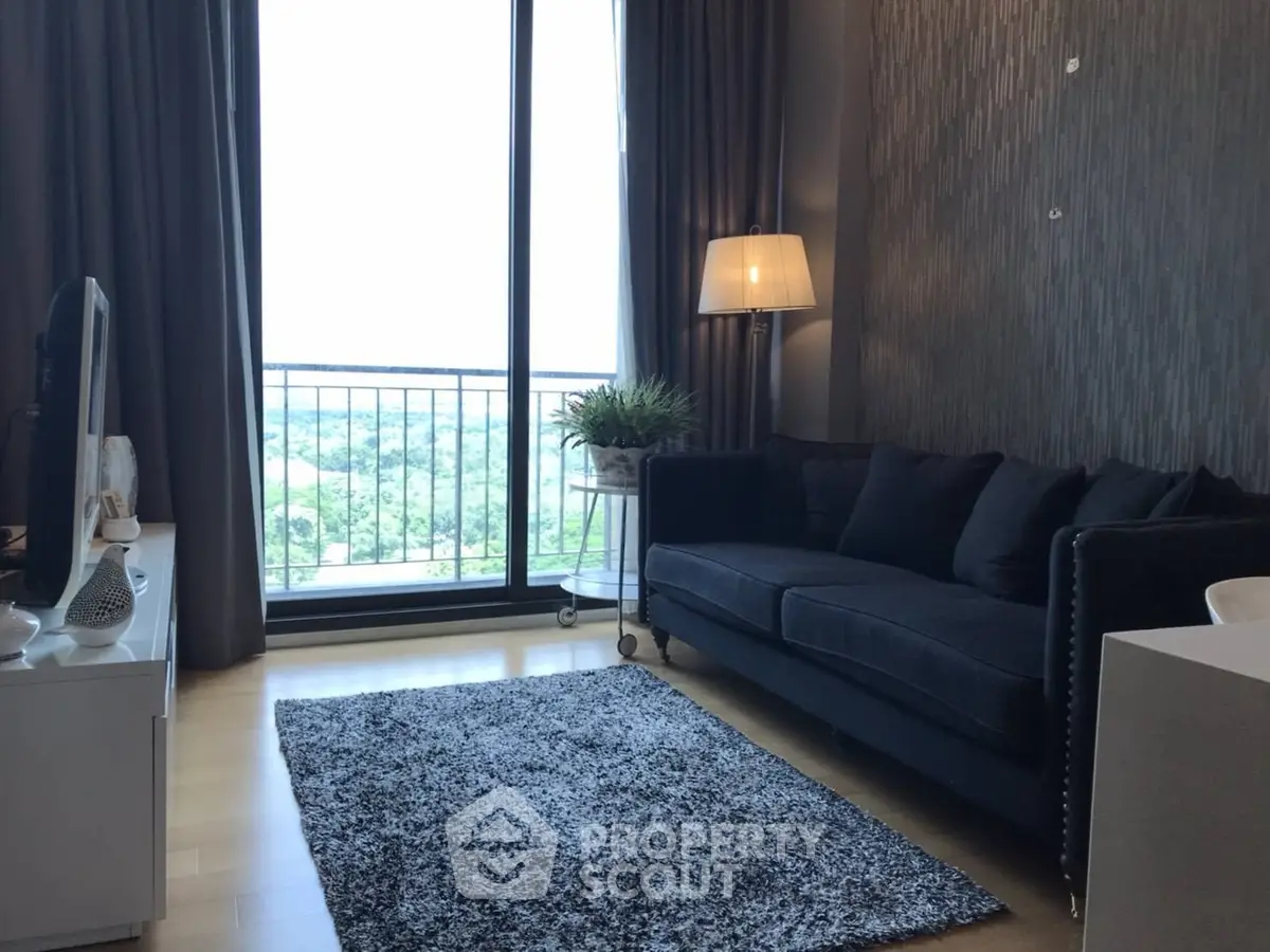 Stylish living room with modern decor and large window offering scenic views.