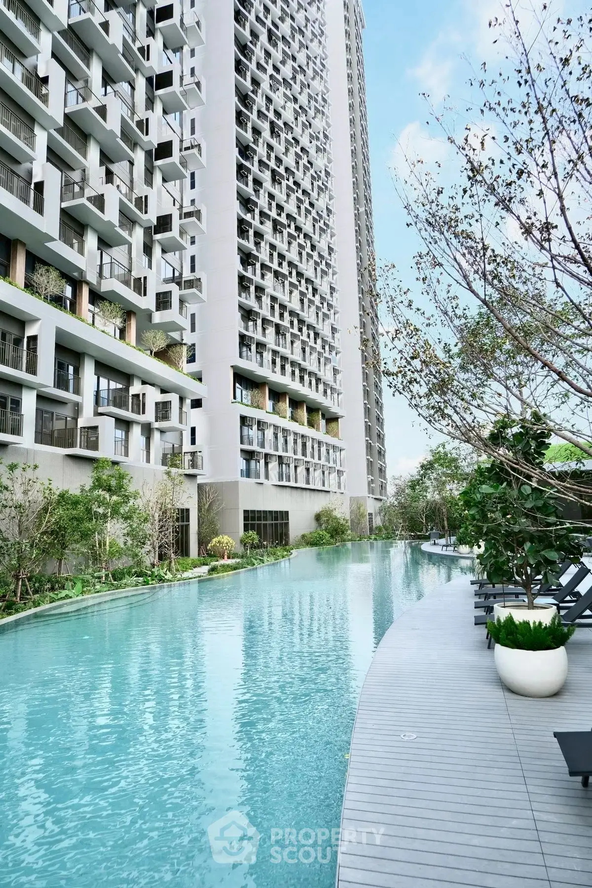 Luxurious high-rise building with stunning poolside view and modern architecture.