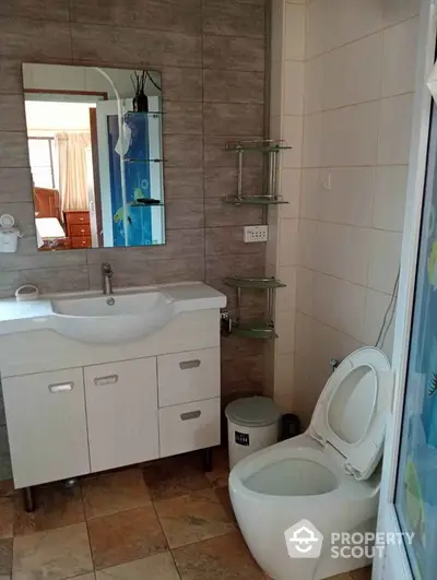 Modern bathroom with stylish sink and mirror, featuring tiled walls and floor.