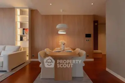 Elegant dining area with modern lighting and cozy seating in a stylish open-plan living space.
