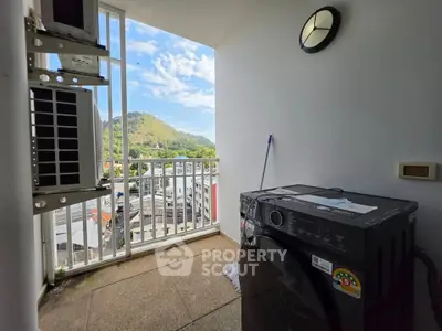 Charming balcony with scenic mountain view and modern washing machine, perfect for urban living.