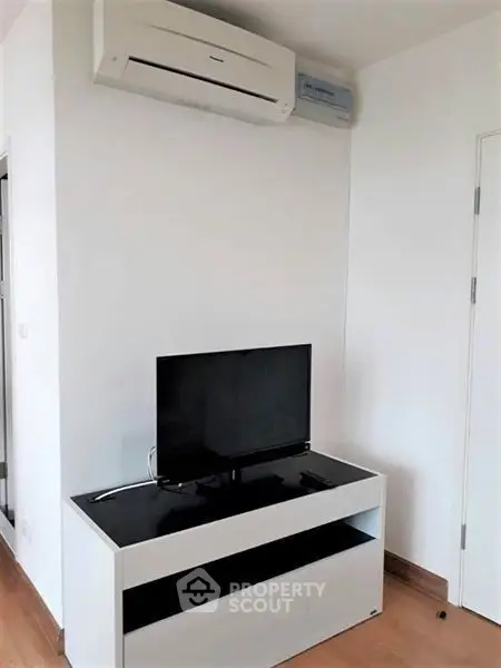 Modern living room with sleek TV stand and air conditioning unit, perfect for cozy entertainment.