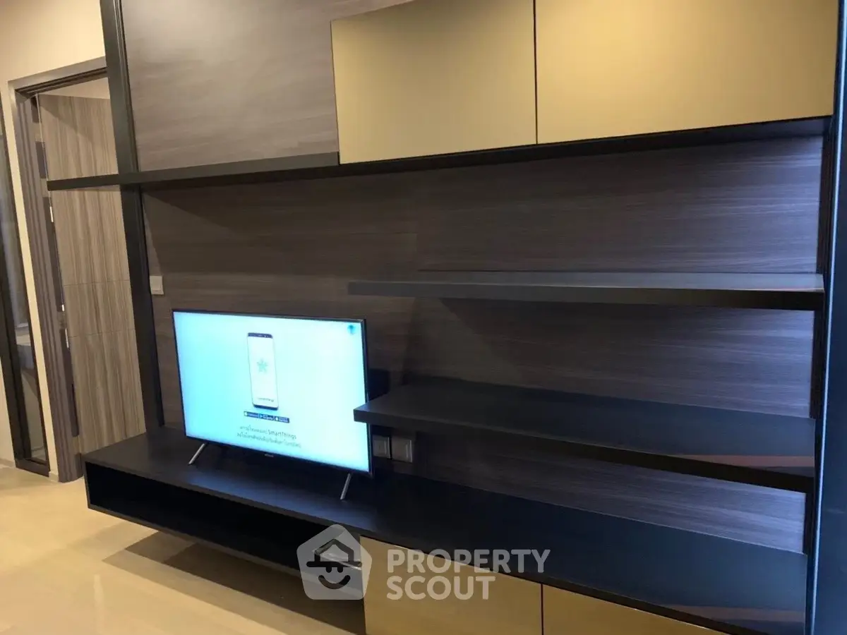 Modern living room with sleek shelving and flat-screen TV, perfect for stylish urban living.