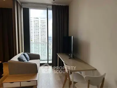 Modern living room with city view, featuring sleek furniture and floor-to-ceiling windows.