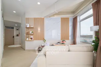 Modern living room with large windows and stylish decor in a high-rise apartment.