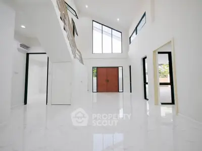Spacious modern living room with high ceilings and large windows in a luxury home.