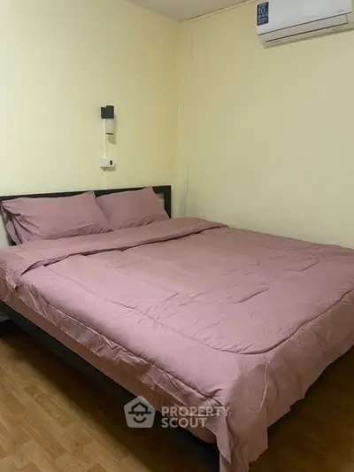 Cozy bedroom with double bed and air conditioning in a minimalist setting.