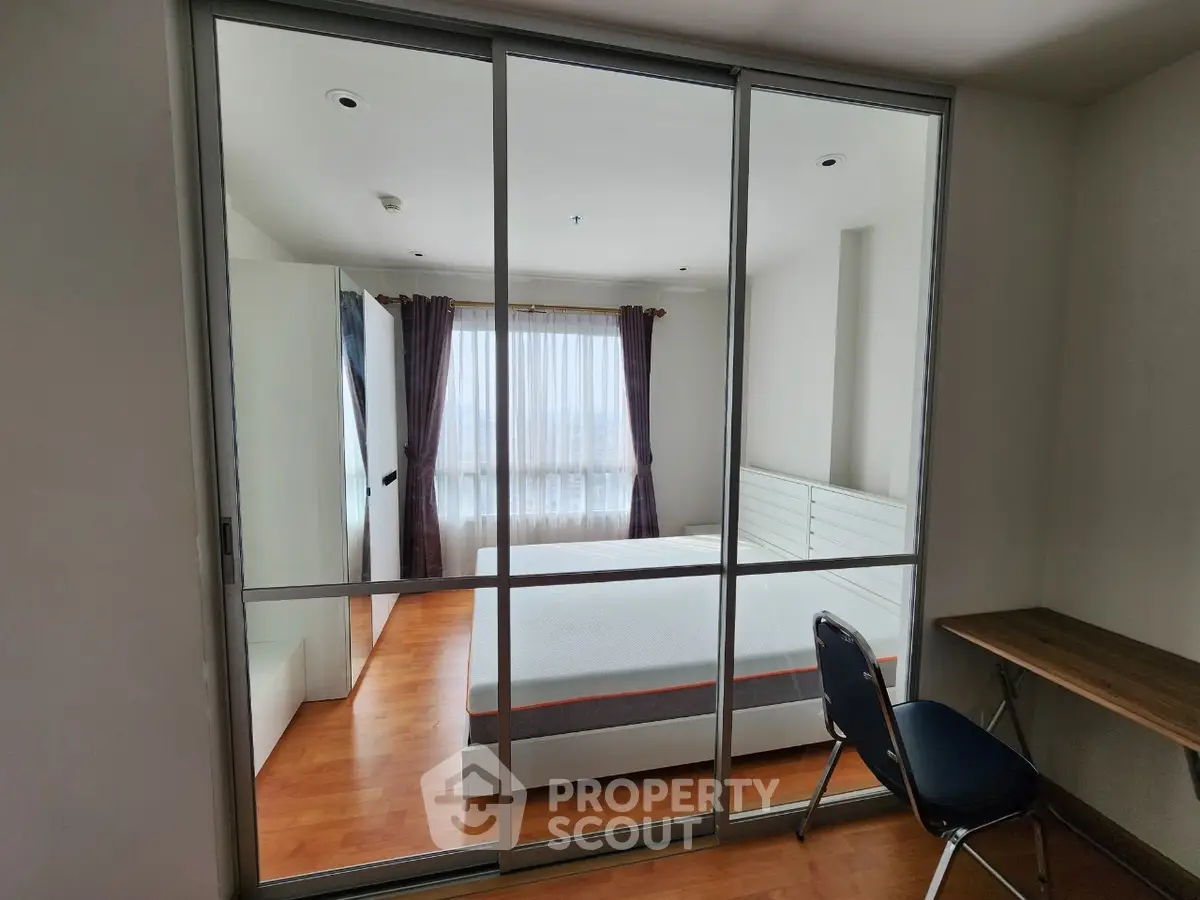 Modern bedroom with glass sliding doors and wooden flooring