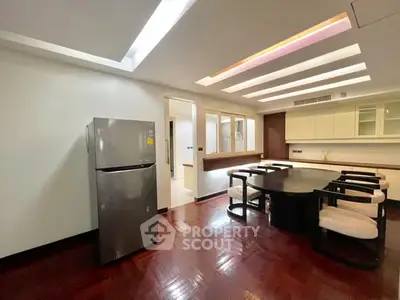 Spacious dining area with modern lighting and sleek refrigerator