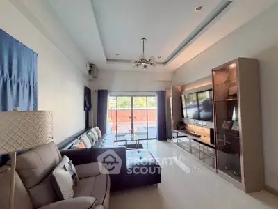 Spacious living room with modern decor and large TV, perfect for relaxation.