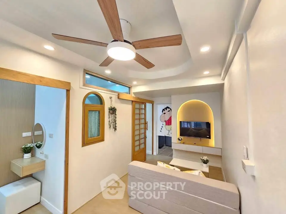 Charming living room with modern ceiling fan and cozy decor, perfect for relaxation and entertainment.