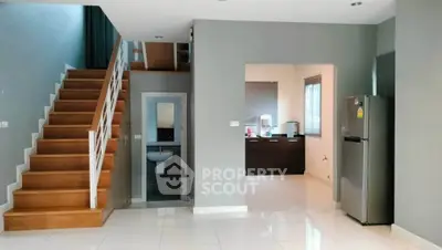 Modern open-plan living space with sleek kitchen and wooden staircase