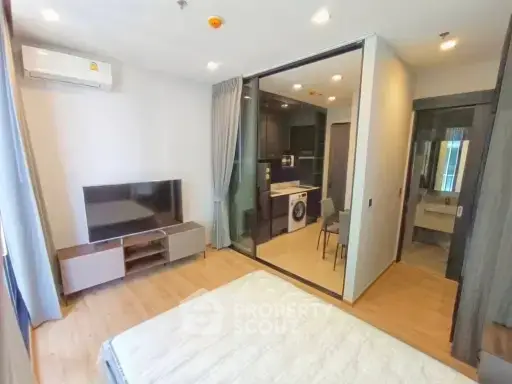 Modern studio apartment with open layout, featuring a compact kitchen and cozy living area.