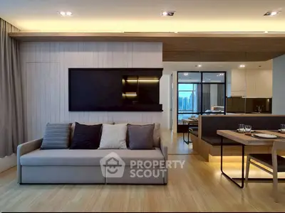 Modern living room with sleek design and open kitchen layout, featuring a cozy sofa and elegant dining area.