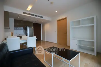 Modern living room with open kitchen and sleek furniture in a stylish apartment.
