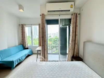 Bright bedroom with balcony view in modern apartment, featuring air conditioning and stylish furnishings.
