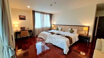 Spacious bedroom with twin beds and elegant wooden flooring