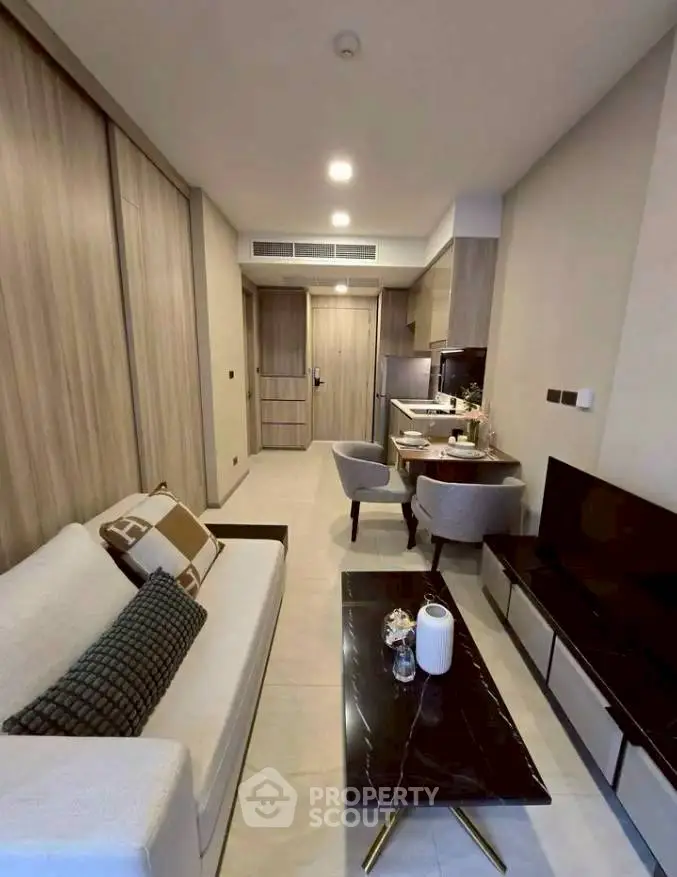 Modern living room with sleek furniture and open kitchen layout, perfect for urban living.