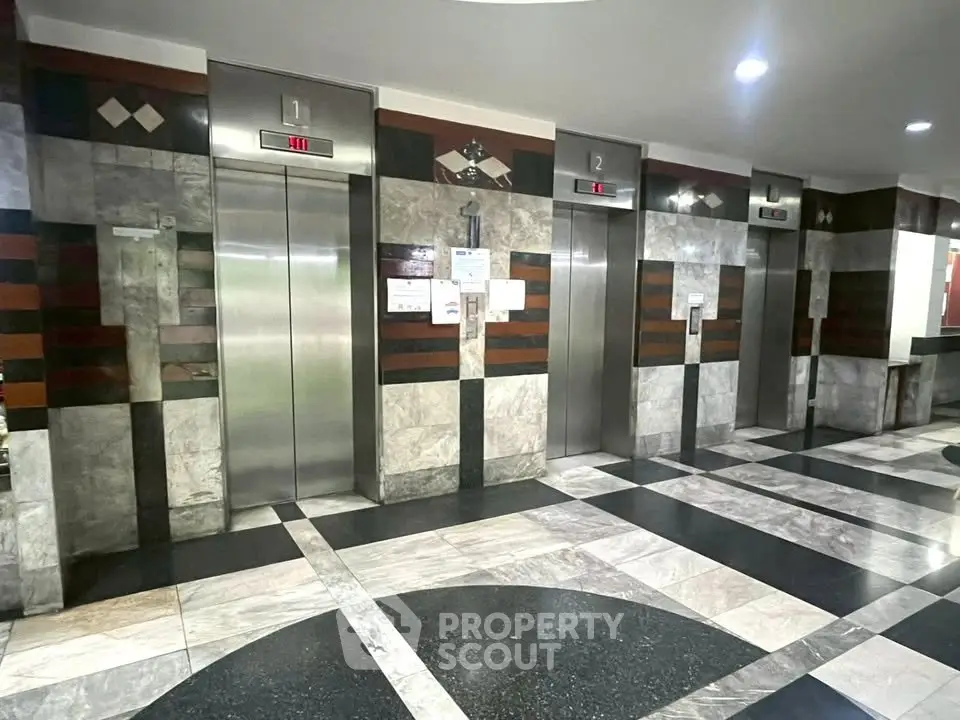 Modern building lobby with multiple elevators and stylish marble flooring.