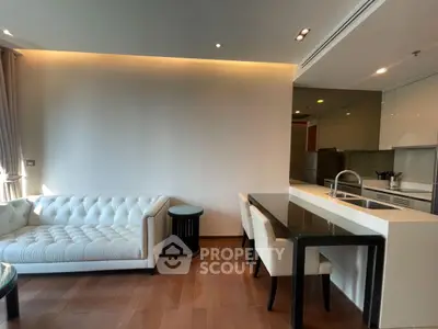 Modern living room with elegant white sofa and sleek kitchen area
