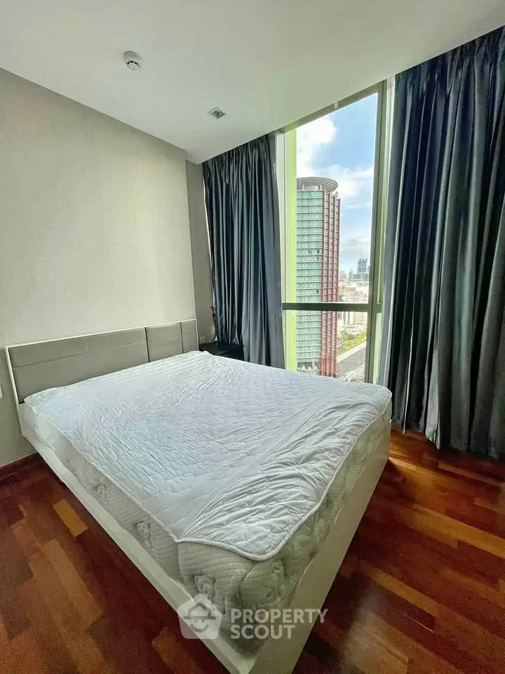 Modern bedroom with large window offering stunning city view