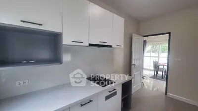 Modern kitchen with sleek cabinetry and gas stove, leading to a bright dining area.