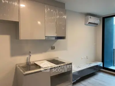Modern kitchen with sleek cabinetry and air conditioning in a contemporary apartment.
