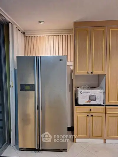 Modern kitchen with stainless steel fridge and wooden cabinets