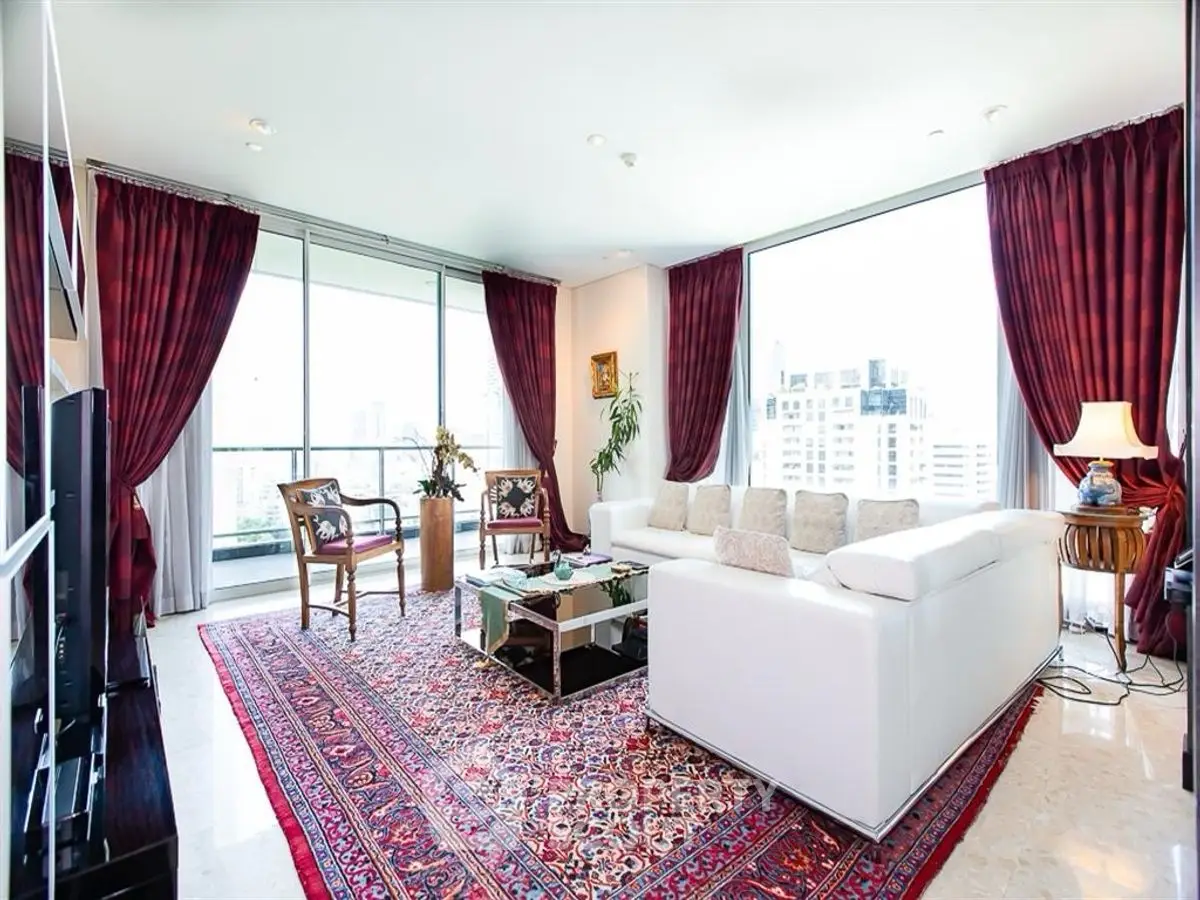 Luxurious living room with panoramic city views, elegant decor, and plush white sofa.