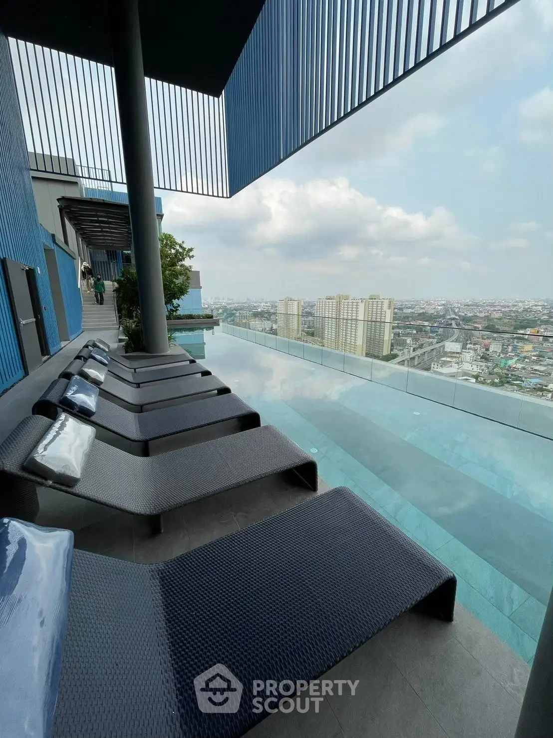 Stunning rooftop pool with panoramic city views and modern lounge chairs.
