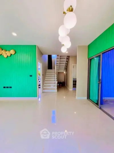 Spacious modern living room with vibrant green accent wall and elegant lighting