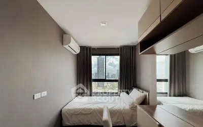Modern bedroom with city view and sleek furnishings in high-rise apartment.