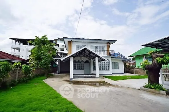 Charming two-story house with lush green lawn and spacious driveway