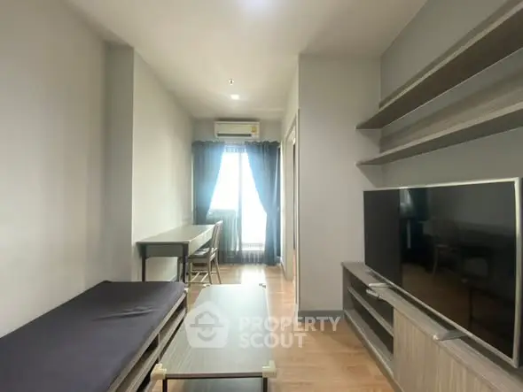 Modern living room with sleek furniture and large TV, perfect for relaxation.