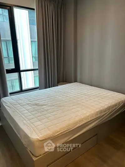 Cozy bedroom with modern design and large window for natural light.