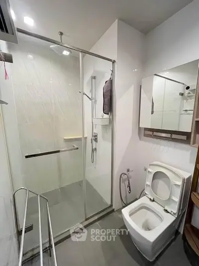 Modern bathroom with glass shower and sleek fixtures in a contemporary apartment.