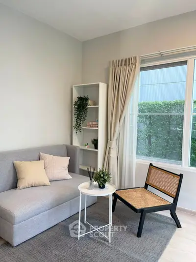 Chic living room with modern sofa, stylish chair, and large window view.