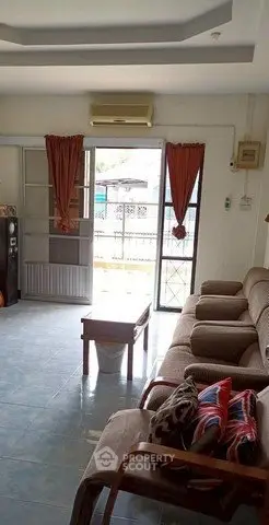 Spacious living room with cozy seating and natural light, perfect for relaxation.