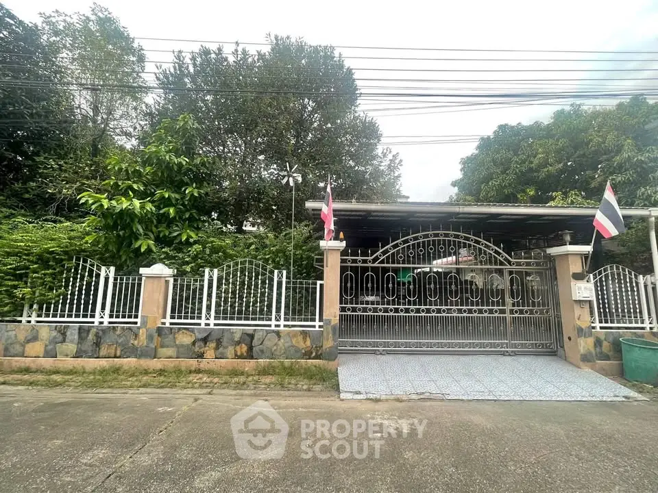 Charming gated property with lush greenery and secure entrance in a serene neighborhood.