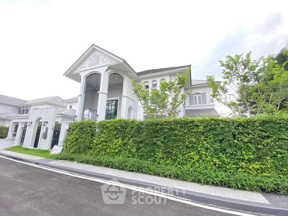 Elegant luxury home with lush greenery and classic architectural design