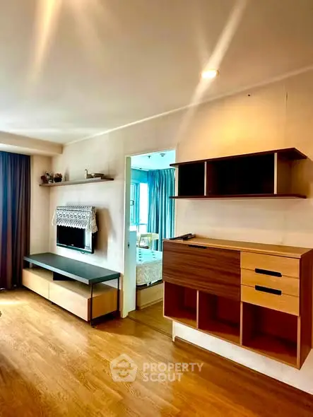 Modern living room with stylish wooden furniture and TV, featuring a cozy ambiance and natural light.
