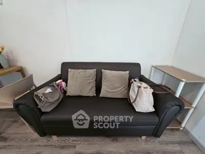 Cozy living room with a stylish black sofa and modern decor, perfect for relaxation and entertaining.