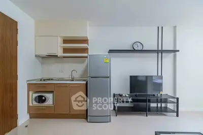 Modern studio apartment with compact kitchen and living area featuring sleek appliances and minimalist design.