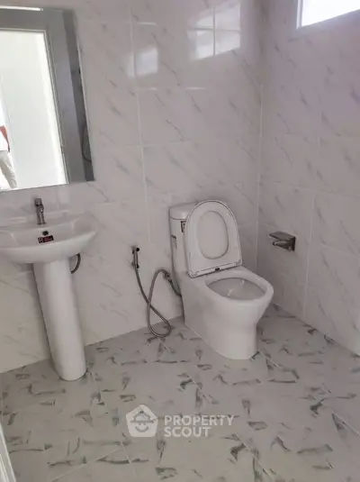 Modern bathroom with sleek white fixtures and tiled walls