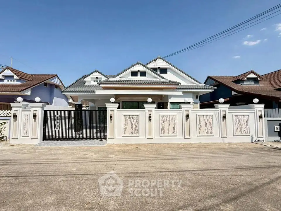 Charming suburban house with elegant gated entrance and modern roof design.
